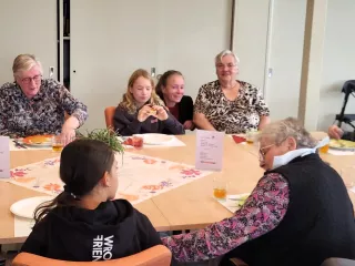Jongeren en ouderen samen aan tafel en met elkaar in gesprek
